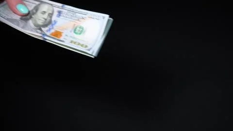 Hands counting US Dollar bill or paying in cash on black background. Payment Stock Photos