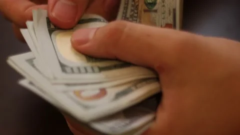 Hands counting US Dollar bills or paying in cash on money background. Stock Footage 139780328