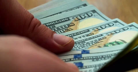 Hands counting US Dollar bills or paying in cash on money background. Concept of Stock Footage 152104475