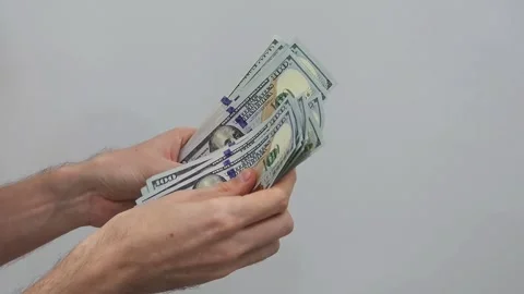 Hands counting US dollar bills against a plain background. Stock Footage 286906440