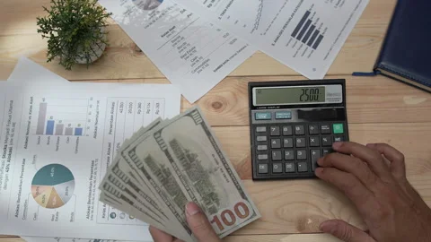Hands counting US dollar bills and using a calculator Stock-Footage 346771295