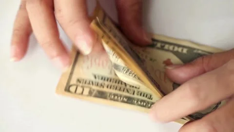 Hands counts dollar bills on a table on a white background, close-up view. Stock Footage 336263776