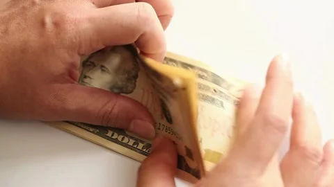 Hands counts dollar bills on a table on a white background, close-up view. Stock-Footage 336264776