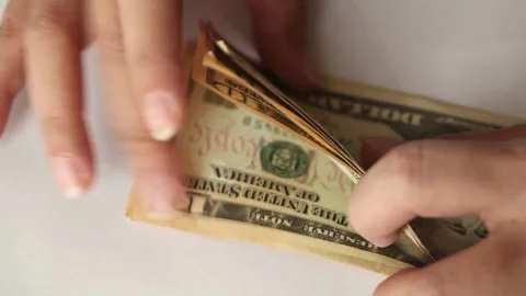 Hands counts dollar bills on a table on a white background, close-up view. Stock-Footage 336264831