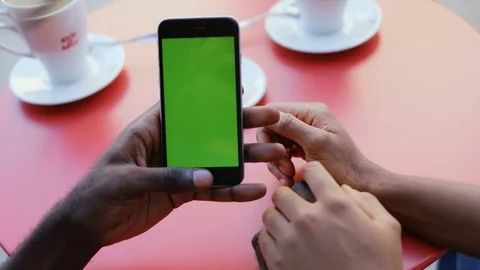 Hands of couple in love lying at red table in cafeteria and holding smartphone Stock Footage 81835621