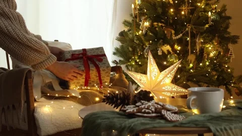 Hands in cozy sweater putting stylish wrapped gift Stock Footage 249829799