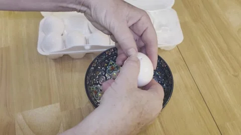 Hands crack second egg into a colorful blue floral patterned bowl Stock Footage 340115158