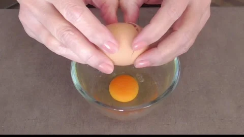 Hands Cracking Eggs into Glass Bowl Stock Footage 345227287