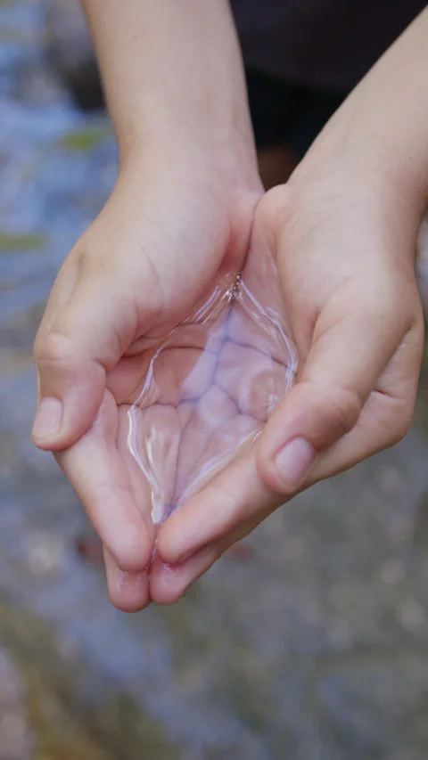 Hands cradle clean water, balancing against ocean pollution Stock Footage 293322377