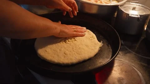 Hands crafting flatbread dough on hot griddle for cooking Stock Footage 301402901