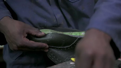 Hands Crafting Leather Shoe with Precision Tools in Workshop Stockbeeldmateriaal 336039177