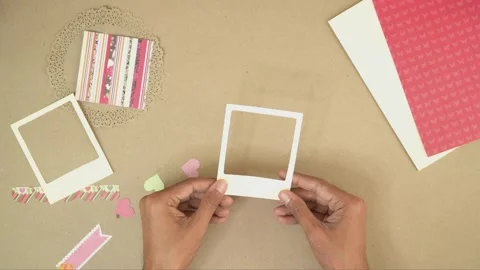 Hands crafting with paper frames and cutouts for vintage scrapbook Stock Footage 289273259