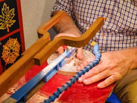 Hands of a craftsman cut out a pattern from wood with a jigsaw Foto stock