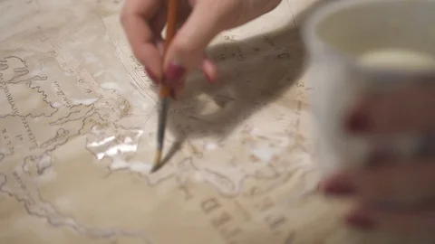 Hands create aged map with paint brush and white watercolor, close-up Stock-Footage 94768306
