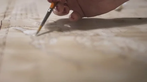 Hands create aged map with paint brush and white watercolor, close-up Stock-Footage 94768327