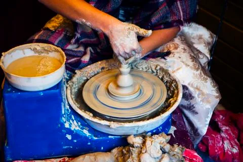 Hands create the shape of a clay product. Work with fingers on modeling the p 库存照片