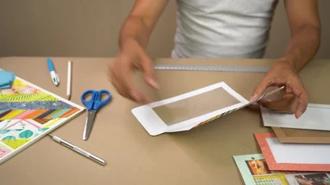 Hands Creating and Decorating Paper Crafts with Tools on Tabletop Workspace Stock Footage 345617047