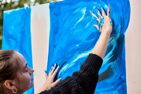 Hands creating art with vivid blue paint Stock Photos