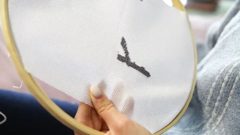 Hands creating cross stitch pattern on white fabric in wooden hoop with nat.. Stock Footage 334955009