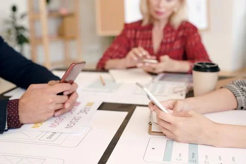 Hands of creative designers or mobile application developers using smartphones Stock Photos