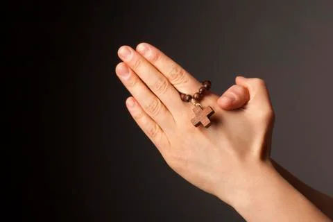 Hands with cross on dark background Stock Photos