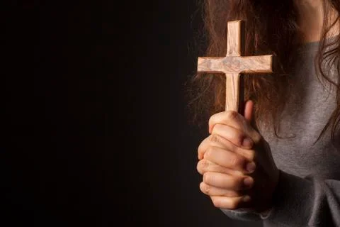 Hands with cross on dark background Stock Photos
