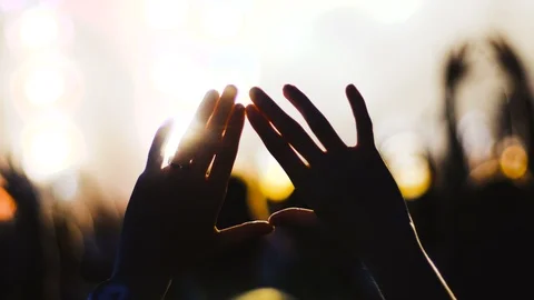 Hands up from a crowd in front of an out of focus stage Stock Footage 94774476