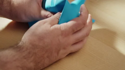 Hands crumpling blue paper close-up. Macro shooting of crumpled sheet. Stock Footage 169237754