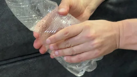 Hands crushing an empty plastic bottle to reduce waste. Environmental pollution, Stock Footage 336524192
