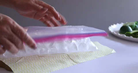 Hands crushing ice in plastic bag with a hammer Video stock 107967059