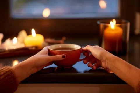 Hands with cup of tea on window sill in autumn Stock Photos