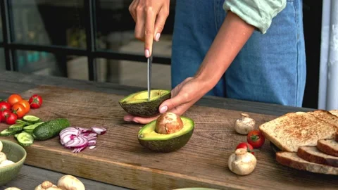 Hands cut avocado toast with vegetables on the wood board Stock Footage 160850436