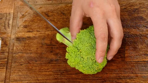 Hands to cut broccoli into slices Video stock 84479120
