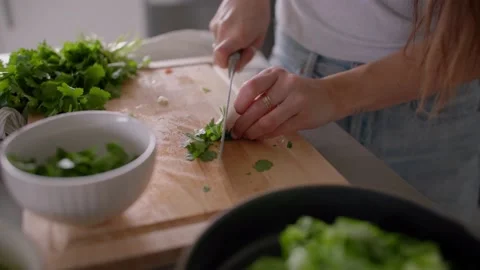 Hands cut cilantro on cutting board in kitchen, chop, cooking food 库存影片 220754804