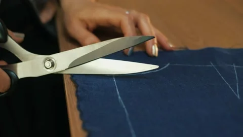 Hands cut the fabric with tailor's scissors, cutting a piece of fabric the Stock-Footage 152097962