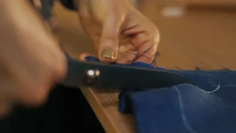 Hands cut the fabric with tailor's scissors, cutting a piece of fabric the Video stock 152097992