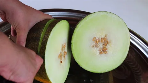 Hands cut a juicy melon with a knife Stock Footage 220871118