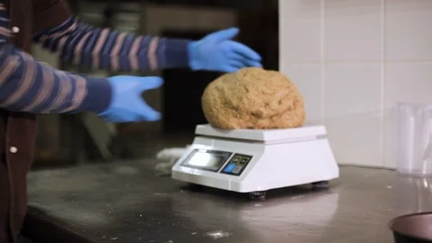 Hands cut a large piece of dough into pieces and put on the scales. Close-up Stock Footage 106460168