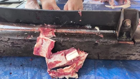 Hands cut meat with a heavy meat cutter Stock Footage 340142613