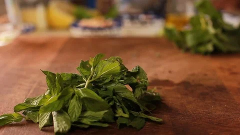 Hands cut mint leaves Fresh mint falling on dark wooden chopping board Stock Footage 78662504