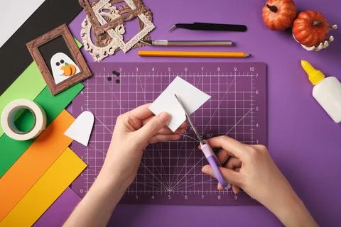 Hands cut out ghost silhouettes from white paper. Stock Photos