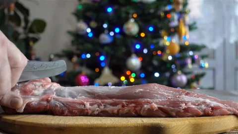 Hands cut a piece of raw meat and Christmas tree in 4K Stock Footage 126141168