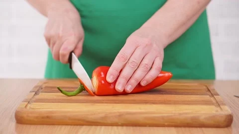 Hands cut red pepper on a cutting board. Stock Footage 170078087