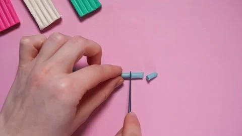 Hands cut a roll of blue plasticine with a plastic blue safety knife. Stock Footage 167538830