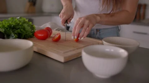 Hands cut tomatoes on cutting board in kitchen, chop, cooking food 库存影片 220753894