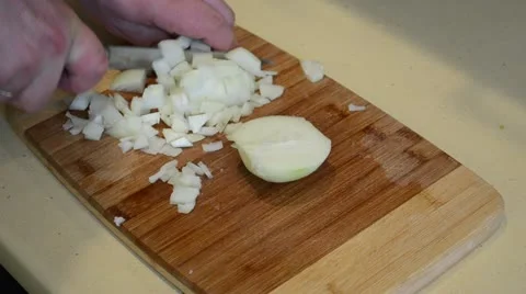 Hands cut white onion with knife on board into small pieces Stock Footage