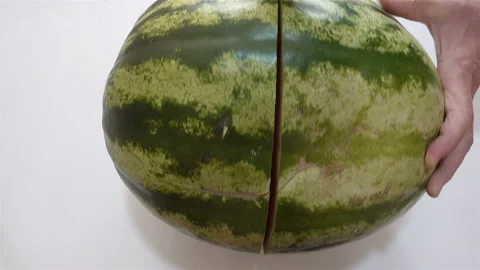 Hands cut a whole watermelon in 4K Stock Footage 140097784