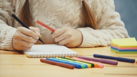 Hands of cute schoolkid drawing with red and black markers. Stock Footage 113071413