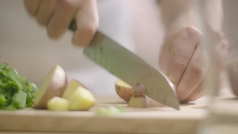Hands cuts potatoes in half on the table Stock Footage 198937033