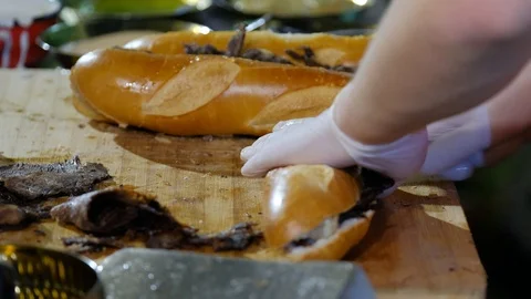 Hands cutting baguette filled with pulled duck meat sandwich. Stock Footage 106617890